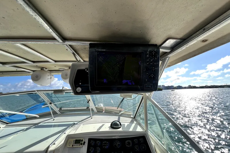 Slide: The Image of 1996 Wellcraft 330 Coastal boat cockpit with navigation system, overlooking sunny ocean view. - 43
