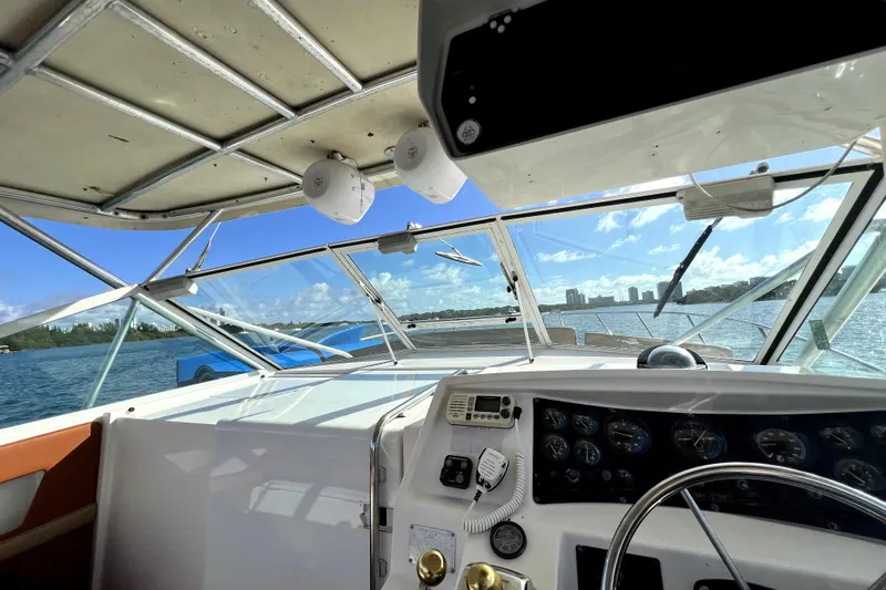 Slide: The Image of 1996 Wellcraft 330 Coastal boat cockpit with ocean view and clear blue sky. - 45