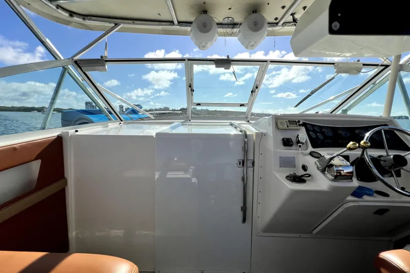 Slide: The Image of 1996 Wellcraft 330 Coastal boat helm with steering wheel, dashboard, and ocean view. - 50
