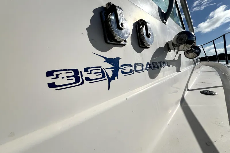 Slide: The Image of 1996 Wellcraft 330 Coastal boat with logo and ocean backdrop. - 36