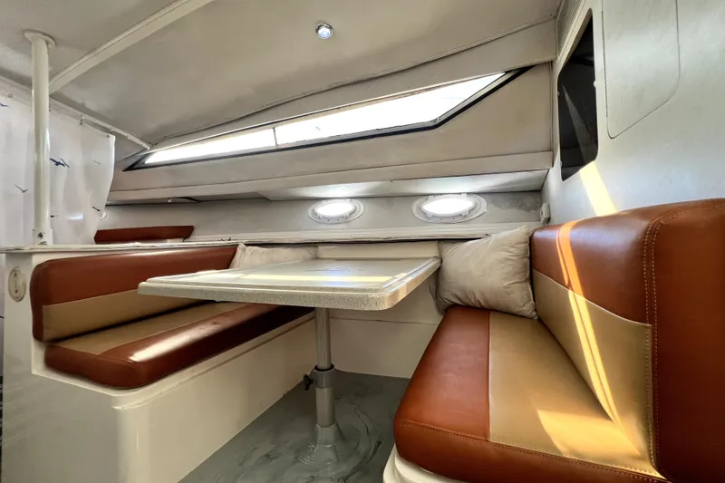 Slide: The Image of 1996 Wellcraft 330 Coastal cabin interior with brown seating and table. - 60