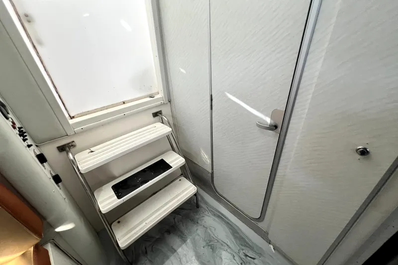 Slide: The Image of Interior of 1996 Wellcraft 330 Coastal boat, featuring steps and a closed door. - 54