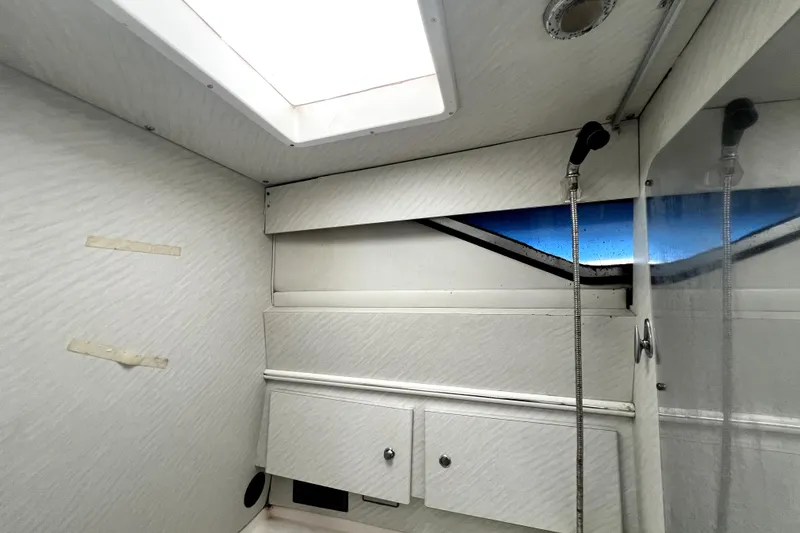 Slide: The Image of Interior of a 1996 Wellcraft 330 Coastal boat, featuring a skylight and storage cabinets. - 57