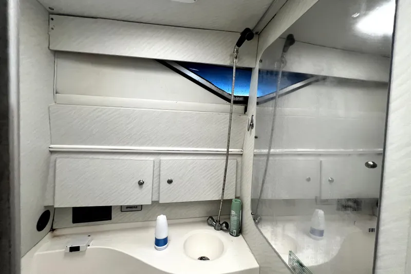 Slide: The Image of 1996 Wellcraft 330 Coastal boat bathroom with sink, mirror, and storage cabinets. - 56