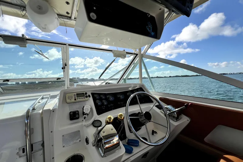 Slide: The Image of 1996 Wellcraft 330 Coastal boat helm with ocean view and clear blue sky. - 46