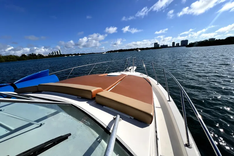 Slide: The Image of 1996 Wellcraft 330 Coastal boat cruising on a sunny day with city skyline in background. - 37