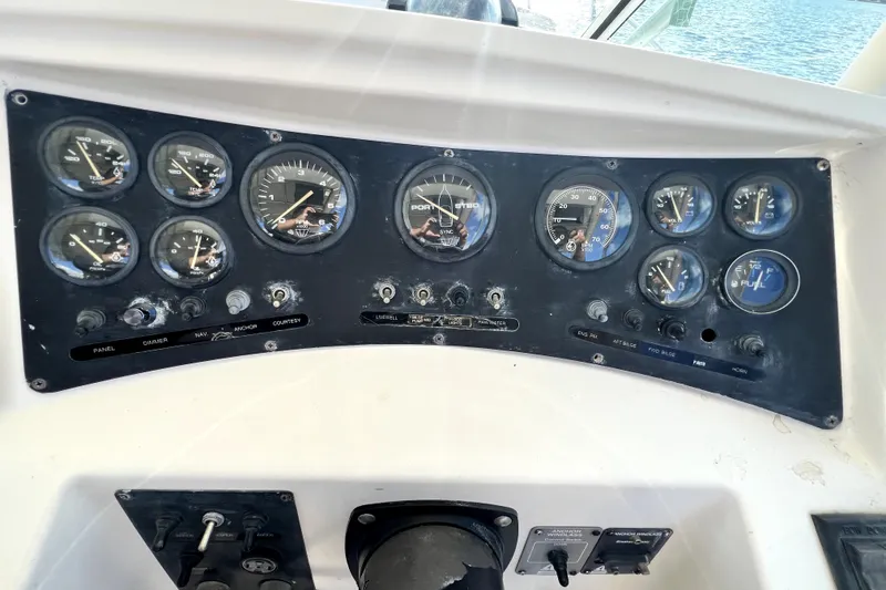 Slide: The Image of 1996 Wellcraft 330 Coastal dashboard with gauges and controls, overlooking water. - 48
