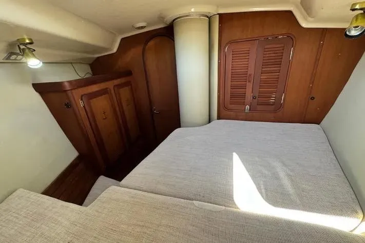 Slide: The Image of Cozy cabin interior of 1993 Hunter Vision 36 sailboat with wooden furnishings and bed. - 14