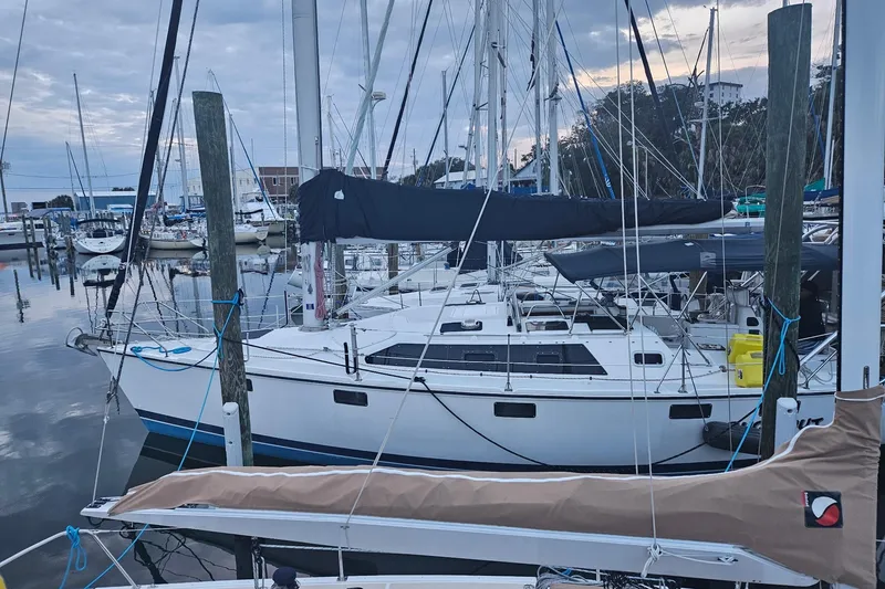 The Image of Hunter Vision 36 sailboat from 1993 docked at a marina under a cloudy sky. - 0
