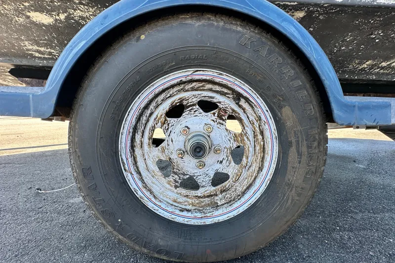 Slide: The Image of Close-up of a weathered trailer wheel on a 1993 Hydra-Sports Bay Bolt 1900. - 64