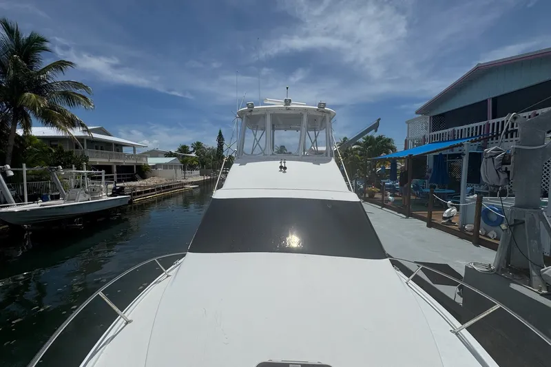 Slide: The Image of Eine Ocean Yachts 35 Super Sport von 1991 liegt an einem Dock, umgeben von Palmen und Gebäuden. - 2
