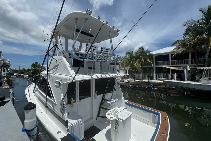 Slide: The Image of 1991 Ocean Yachts 35 Super Sport docked, featuring a spacious deck and fishing equipment. - 6