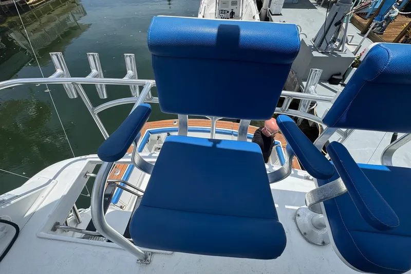 Slide: The Image of Ein blau gepolsterter Stuhl auf einem Boot mit Angelrutenhaltern im Hintergrund. - 27