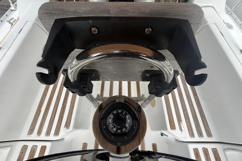 Slide: The Image of The cockpit of a 1990 Beneteau First 35s5 featuring a compass and wooden details. - 12
