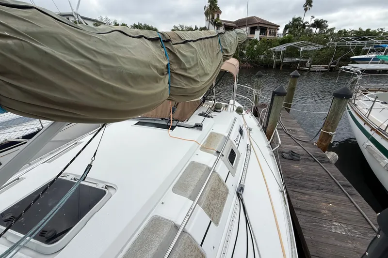 Slide: The Image of 1990 Beneteau First 35s5 sailboat docked, covered mainsail, overcast sky, waterfront view. - 39
