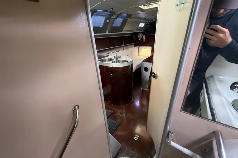 Slide: The Image of Interior of 1990 Beneteau First 35s5 sailboat, featuring a compact kitchen and seating area. - 82