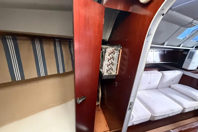Slide: The Image of Interior of 1990 Beneteau First 35s5 yacht, featuring wooden cabinetry and white seating. - 92