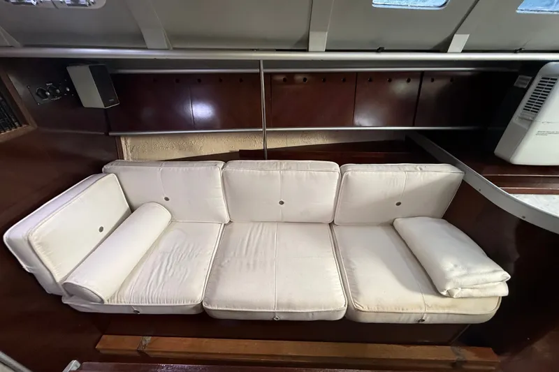 Slide: The Image of Interior of 1990 Beneteau First 35s5 yacht with white cushioned seating. - 88