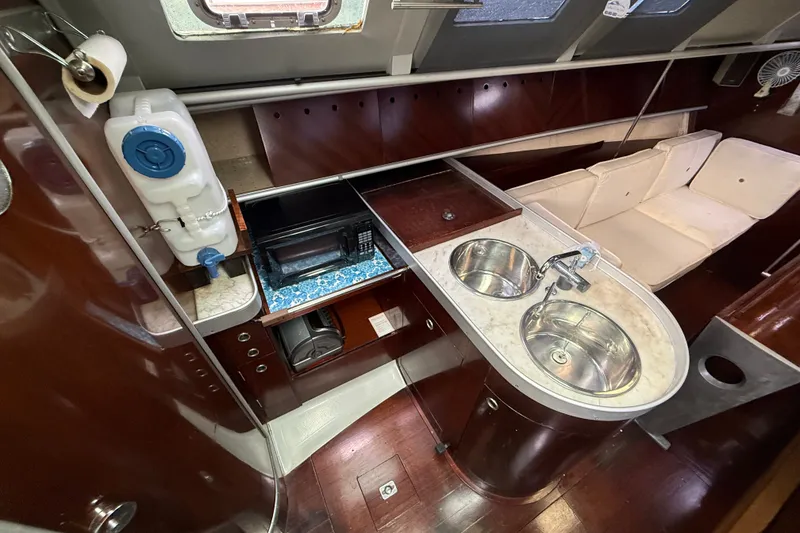Slide: The Image of Interior of 1990 Beneteau First 35s5 yacht with kitchen and seating area. - 55
