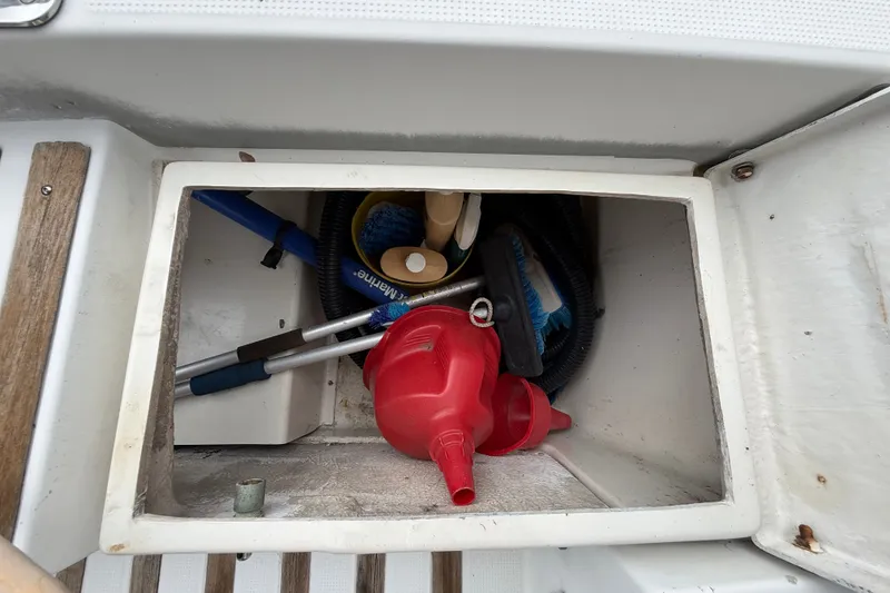 Slide: The Image of Storage compartment on a 1990 Beneteau First 35s5 sailboat with cleaning tools and supplies. - 49