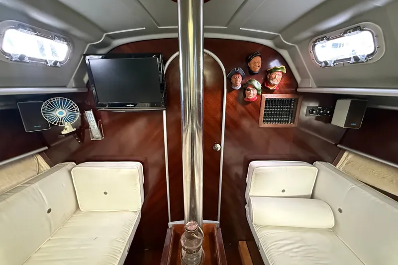 Slide: The Image of Interior of a 1990 Beneteau First 35s5 sailboat with seating, TV, and decor. - 89