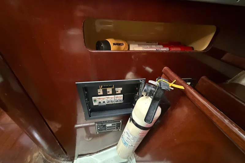 Slide: The Image of Interior of 1990 Beneteau First 35s5 showing fire extinguisher and electrical panel. - 74