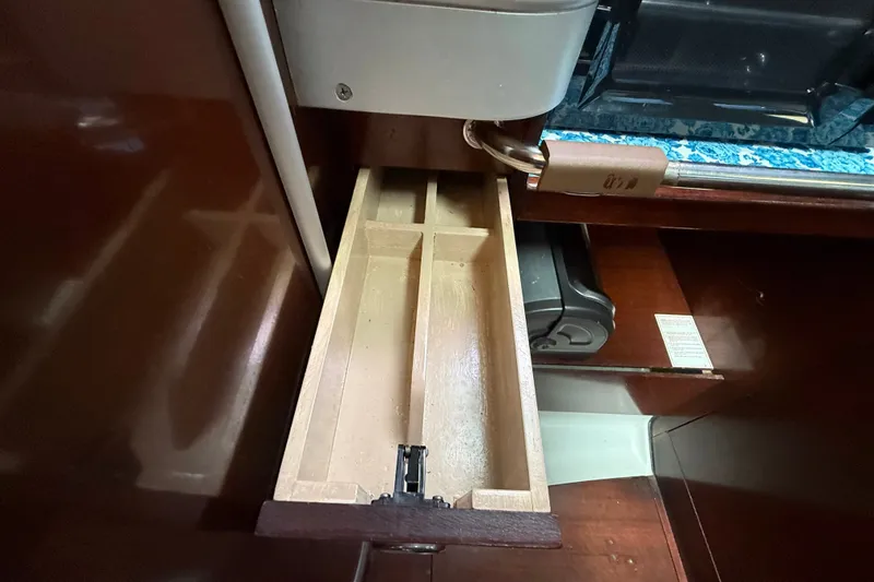 Slide: The Image of Open wooden drawer inside a 1990 Beneteau First 35s5 yacht, showcasing interior storage. - 57