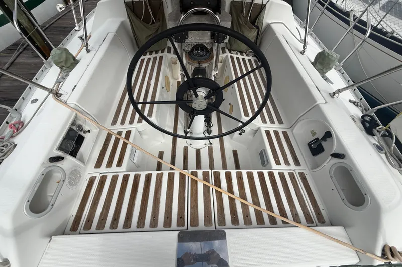 Slide: The Image of Cockpit of 1990 Beneteau First 35s5 sailboat with wooden flooring and steering wheel. - 7