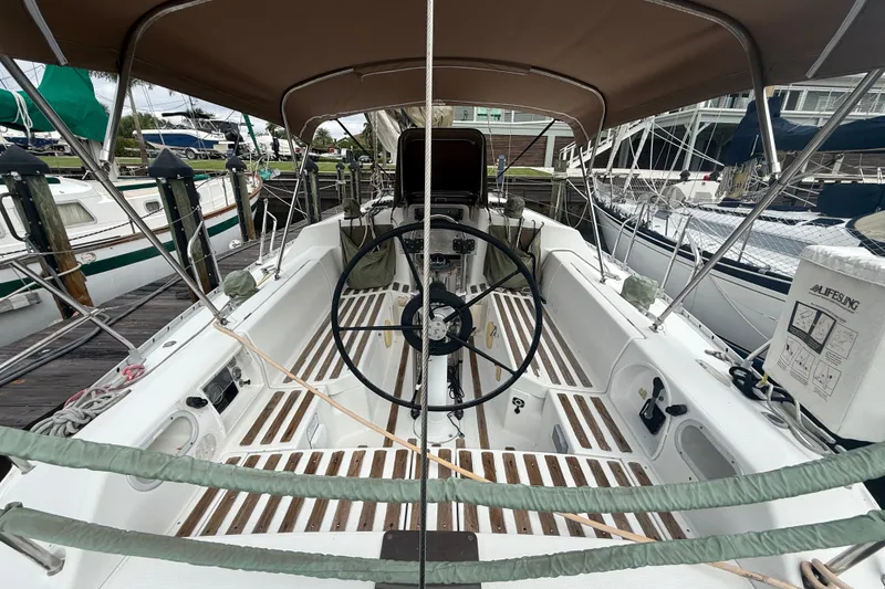 Slide: The Image of The cockpit of a 1990 Beneteau First 35s5 with a steering wheel and sunshade. - 5