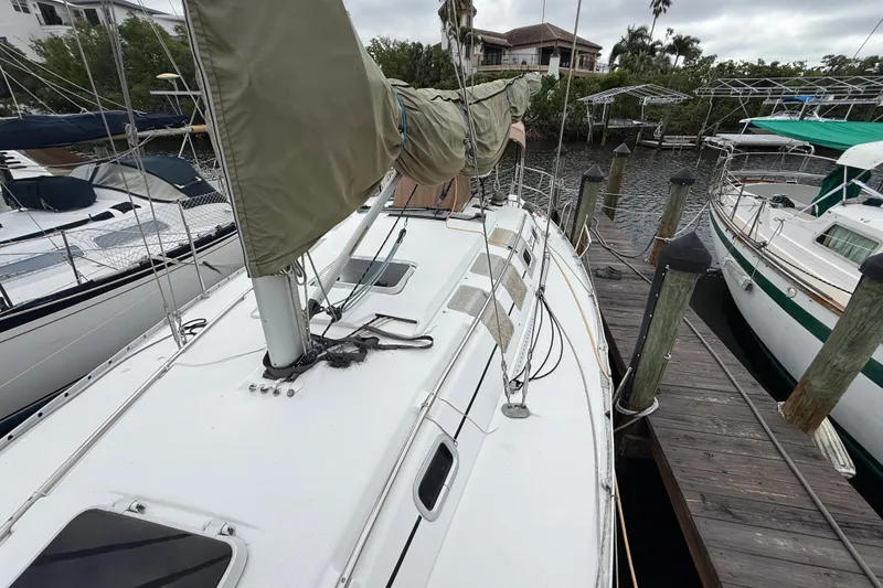 Slide: The Image of 1990 Beneteau First 35s5 sailboat docked, showcasing deck and rigging details. - 37