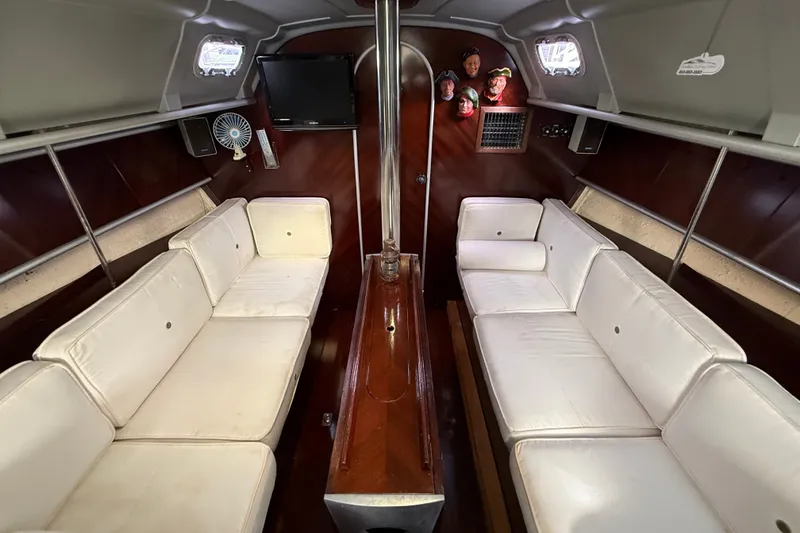 Slide: The Image of Interior of 1990 Beneteau First 35s5 sailboat with white seating and wood accents. - 85