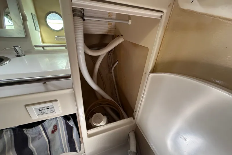 Slide: The Image of Interior plumbing of 1990 Beneteau First 35s5 sailboat, featuring sink and storage area. - 81