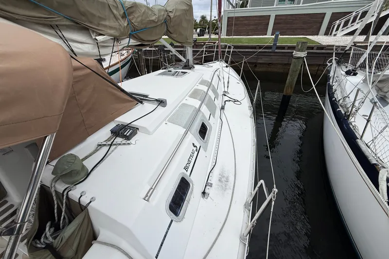 Slide: The Image of 1990 Beneteau First 35s5 sailboat docked, featuring sleek design and covered sails. - 23