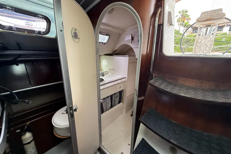 Slide: The Image of Interior of 1990 Beneteau First 35s5 sailboat showing compact bathroom and wooden stairs. - 75