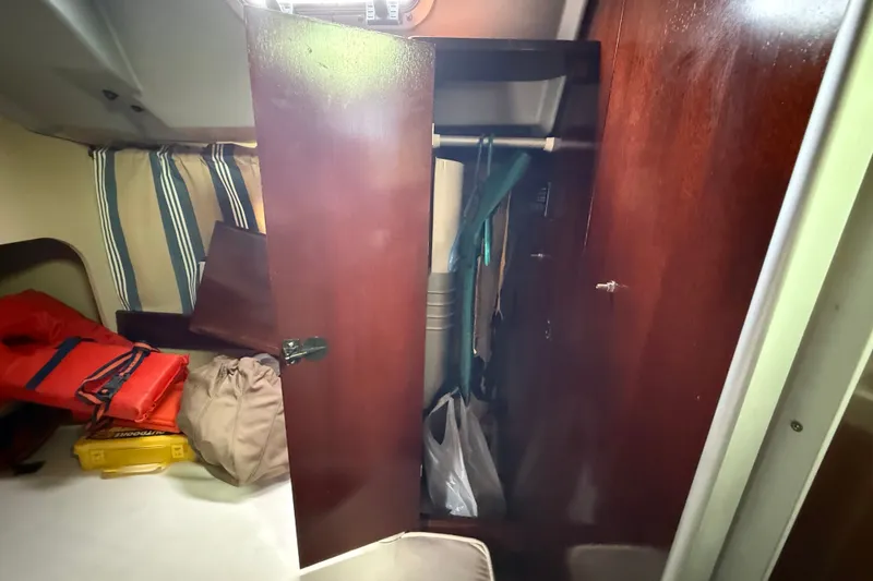 Slide: The Image of Interior of 1990 Beneteau First 35s5 sailboat with open wooden storage cabinet. - 63