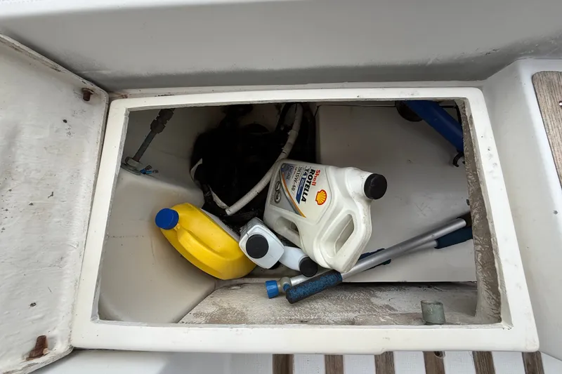 Slide: The Image of Storage compartment on a 1990 Beneteau First 35s5 sailboat with oil containers and tools. - 50