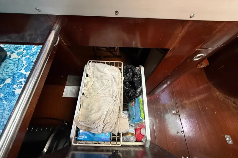Slide: The Image of Storage compartment in a 1990 Beneteau First 35s5 sailboat with various items. - 67