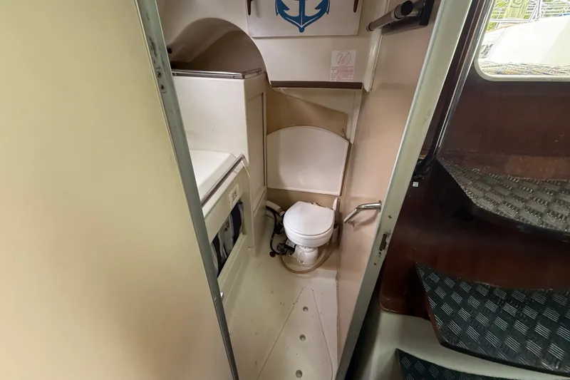 Slide: The Image of Interior view of a 1990 Beneteau First 35s5 sailboat bathroom with toilet and compact design. - 76