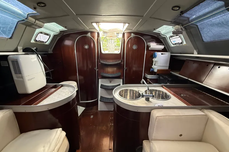 Slide: The Image of Interior of 1990 Beneteau First 35s5 sailboat with modern amenities and wood finish. - 99