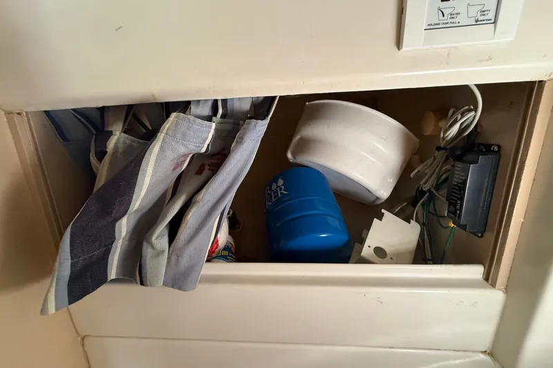 Slide: The Image of Storage compartment in a 1990 Beneteau First 35s5 sailboat with various items. - 80