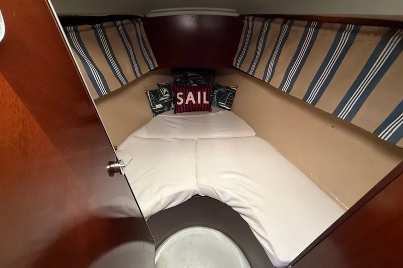 Slide: The Image of Cozy cabin interior of 1990 Beneteau First 35s5 sailboat with striped cushions. - 91