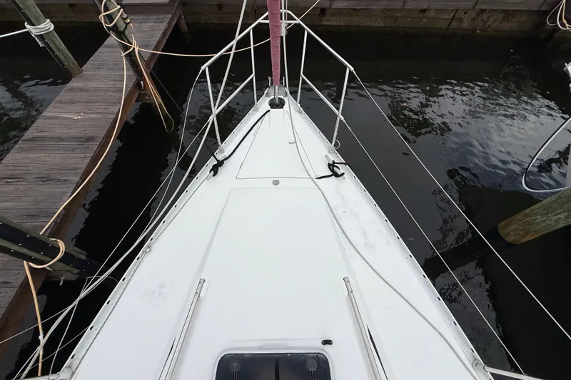Slide: The Image of Bow view of a 1990 Beneteau First 35s5 sailboat docked at a marina. - 31