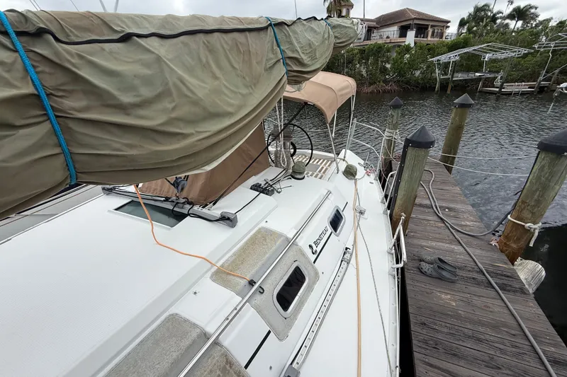 Slide: The Image of 1990 Beneteau First 35s5 sailboat docked, covered mast, wooden pier, waterfront view. - 40