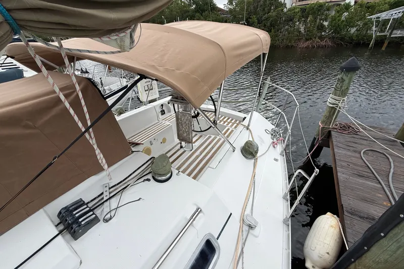 Slide: The Image of 1990 Beneteau First 35s5 sailboat docked, featuring beige canopy and deck details. - 42