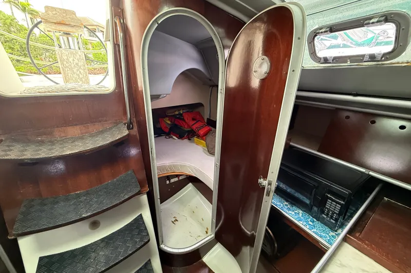 Slide: The Image of Interior of a 1990 Beneteau First 35s5 sailboat, featuring wooden stairs and cozy cabin space. - 60