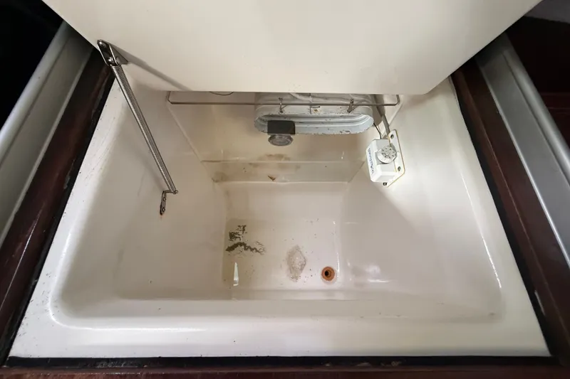 Slide: The Image of Open storage compartment in 1990 Beneteau First 35s5 sailboat, featuring a white interior. - 70