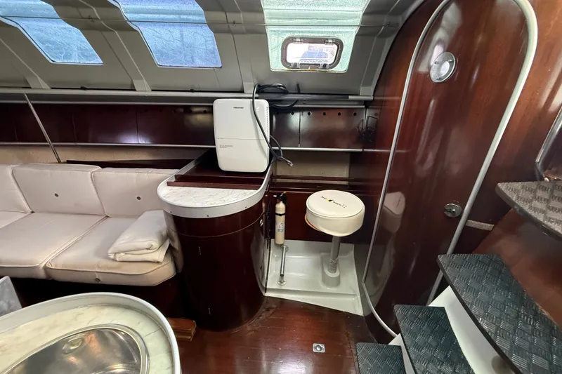 Slide: The Image of Interior of 1990 Beneteau First 35s5 yacht with seating, compact kitchen, and stairs. - 71