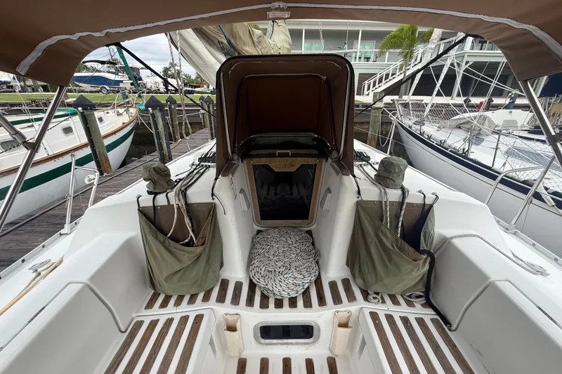 Slide: The Image of Cockpit of a 1990 Beneteau First 35s5 sailboat, docked with open hatch and storage bags. - 17