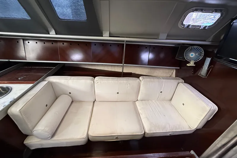 Slide: The Image of Interior of 1990 Beneteau First 35s5 yacht with white cushioned seating. - 87