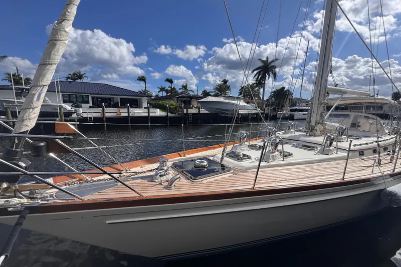 Slide: The Image of 1989 Little Harbor Sloop 58' docked, showcasing sleek design and polished deck under blue skies. - 3